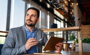 Successful young business man review his Human Sunergistics LSI report on his tablet